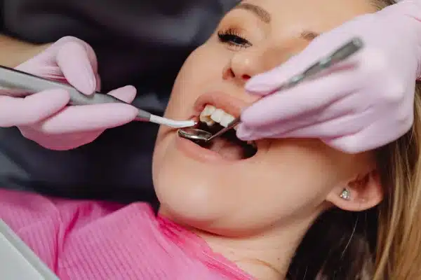 Frisco dentist inspecting a patient's smile before cosmetic dentistry treatment
